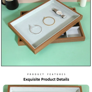 Close-up of wooden jewelry display tray with grey velvet lining for rings and watches