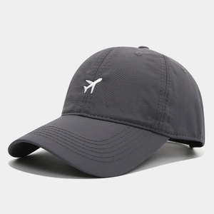 Détail d'une casquette de baseball gris foncé avec broderie avion sur tissu technique