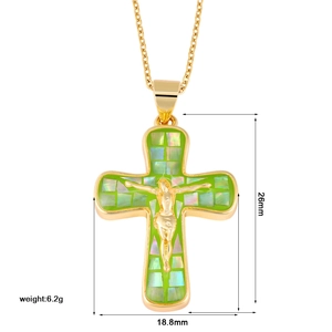 Macro detail of a gold cross pendant with green mosaic inlay and Jesus relief, 26x18.8mm