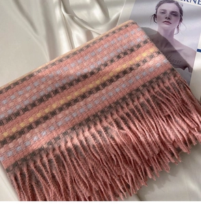 Detail of pink rainbow plaid scarf featuring long tassels on a silk background
