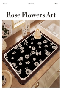 Close-up of a kitchen draining mat with black and white rose floral print on a wooden desk