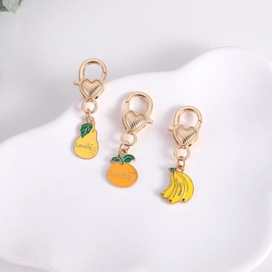 Detail of fruit charms including pear, orange, and banana with heart-shaped lobster clasps