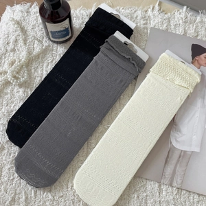 Minimalist lace mesh calf socks in black, grey and beige on a soft plush background