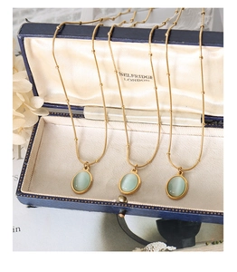 Detailed macro view of 18k gold plated cat eye opal necklaces in a vintage jewelry box
