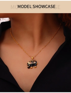 Model wearing gold elephant pendant necklace with colorful crystals on black top