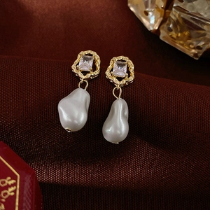 Vintage gold baroque pearl earrings with square zircon studs on deep red velvet