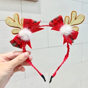 Detail of Christmas headband with gold glitter antlers, red bows, and soft white pom-poms