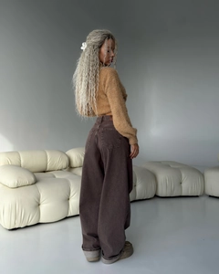 Primo piano di maglione in maglia kaki e pantaloni a zampa marrone scuro a gamba larga