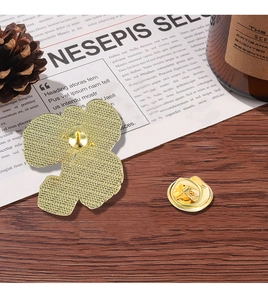Detail of flower brooch back with textured metal finish and secure butterfly clasp