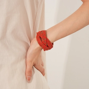 Détail d'un bracelet manchette rouge multicouche montrant les perles de verre tissées