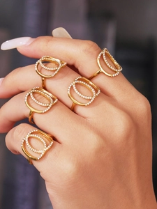 Detail of five-piece gold plated stackable rings with hollow oval pavé zircon settings