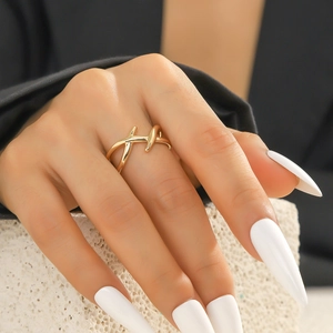 Detailansicht eines überkreuzten goldmetallenen Doppelrings an einem Fingermodel