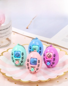 Detail of macaron-colored rock-paper-scissors game keychains in a stylish tray
