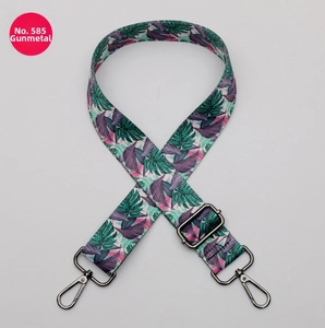 Detail of adjustable polyester strap with tropical leaf print and gunmetal metal hardware