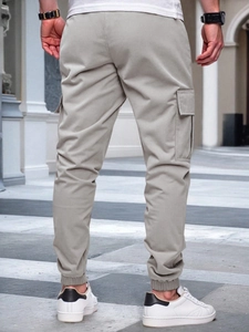 Rear view of men's cargo pants with drawstring waist and functional side pockets