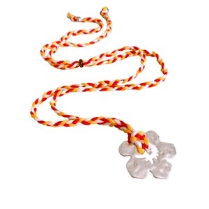 Handmade silver flower pendant necklace with colorful woven cord on a white background