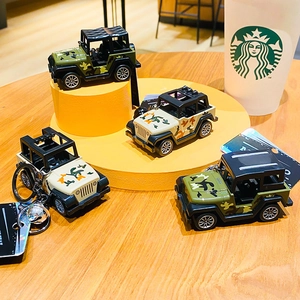3D camo jeep keychains in green and beige patterns on wooden desk surface