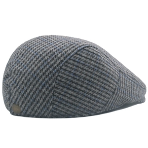 Detail of wool houndstooth plaid flat cap with vintage bronze button and thick texture