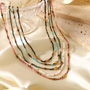 Colorful beaded necklace set with heart pendants on a silk and stone backdrop