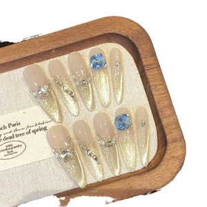 Unghie finte ballerina sfumate glitterate con strass blu su vassoio in legno