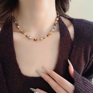 Detail der Perlenkette mit Tigeraugen-Glasperlen am Hals für elegantes Styling