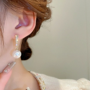 Detailed view of elegant gold-plated zircon heart pearl drop earrings on a female model