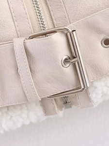 Close-up of cream PU leather jacket with metal buckle detail and soft faux fur lining