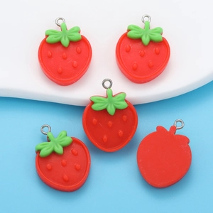 Detailed view of red resin strawberry charms with green leaves and metal rings for DIY jewelry
