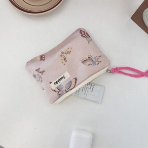 Close-up of small pink jacquard butterfly pouch with zipper and pink rope handle detail