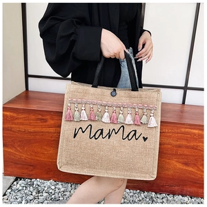 Detail of jute tote bag with mama print and colorful decorative tassel trim fringe