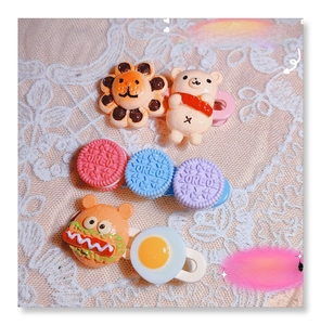 Close-up of cute macaron resin hair clips with animal, burger, and biscuit shapes