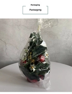 Mini Christmas pine tree with red berries and white flowers in plastic packaging