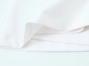 Detailed close-up of premium white fabric hem featuring high-quality precision stitching
