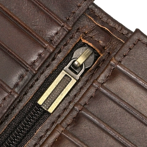 Detailed macro view of dark brown genuine leather wallet with card slots and bronze zipper