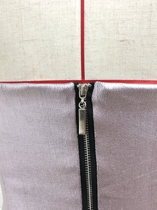 Detail eines metallisch violetten Paillettenkleides mit hochwertigem Reißverschluss