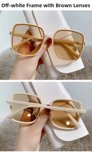 Detail of square sunglasses with cream frame and brown lenses next to a leather case