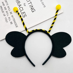 Detail shot of a black and yellow bee headband with fuzzy antennae and felt wings