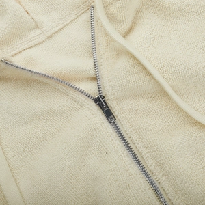 Detailansicht des Reißverschlusses und cremefarbenen Frottierstoffs am Hoodie