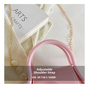 Pink macaron jelly bag showing details of the top handle and adjustable gold chain strap