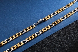 Détail macro du collier chaîne Figaro bicolore or et argent avec fermoir mousqueton
