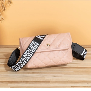 Detailed shot of pink quilted crossbody bag with black and white woven fashion strap