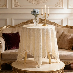 Close-up of vintage floral hollow lace tablecloth with decorative fringe tassels