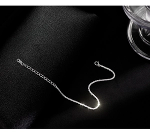 Detailed macro of a shimmering S925 silver chain bracelet with adjustable spring clasp