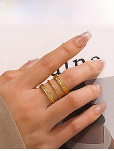 Close-up of three-piece 18K gold plated ring set with hammered texture and polished bands