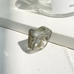 Macro shot of geometric resin ring featuring gray and white marble texture and sleek design
