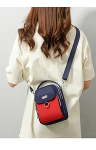 Vertical blue and red crossbody bag detail showing multi-layer zipper and nylon texture