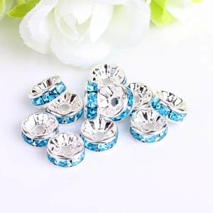 Detailed view of silver rondelle spacer beads with light blue rhinestones for DIY jewelry