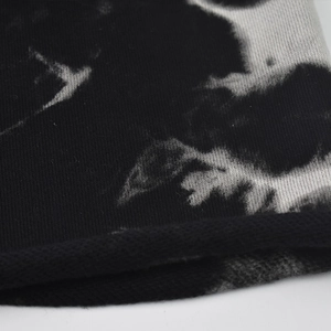 Detailed macro view of black and white tie-dye knit fabric texture on a slouchy beanie hat