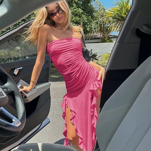 Detail of hot pink tube dress featuring dense ruching and asymmetrical ruffled hemline