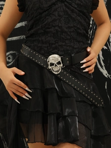 Détail d'une ceinture punk en cuir avec boucle tête de mort en strass et rivets en métal